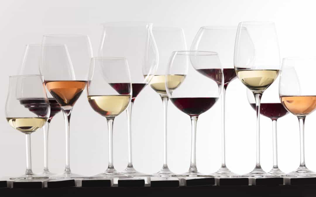Image of multiple wine glasses with red, white, and rose wines in them
